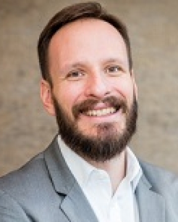 Profile photo of Professor Zachariadis, white male, dark hair, wearing a full beard and moustache