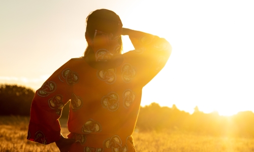 African woman in traditional clothing looking out into the sunset