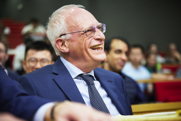 Image of Nobel Laureate Sir Oliver Hart from the inaugural lecture series bearing his name, sat in the audience, smiling 